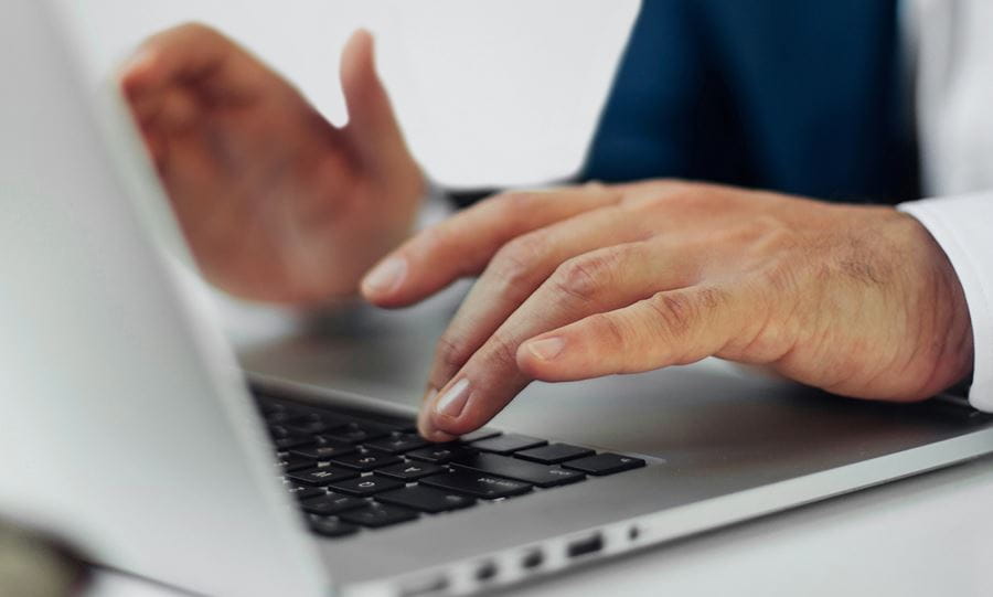fingers typing on a laptop, stands for Press and media at Universal Investment